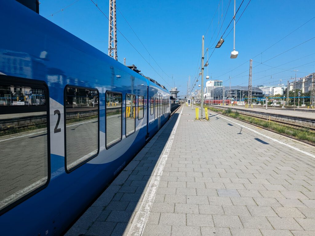 Offener Bahnsteig mit einfahrendem Zug