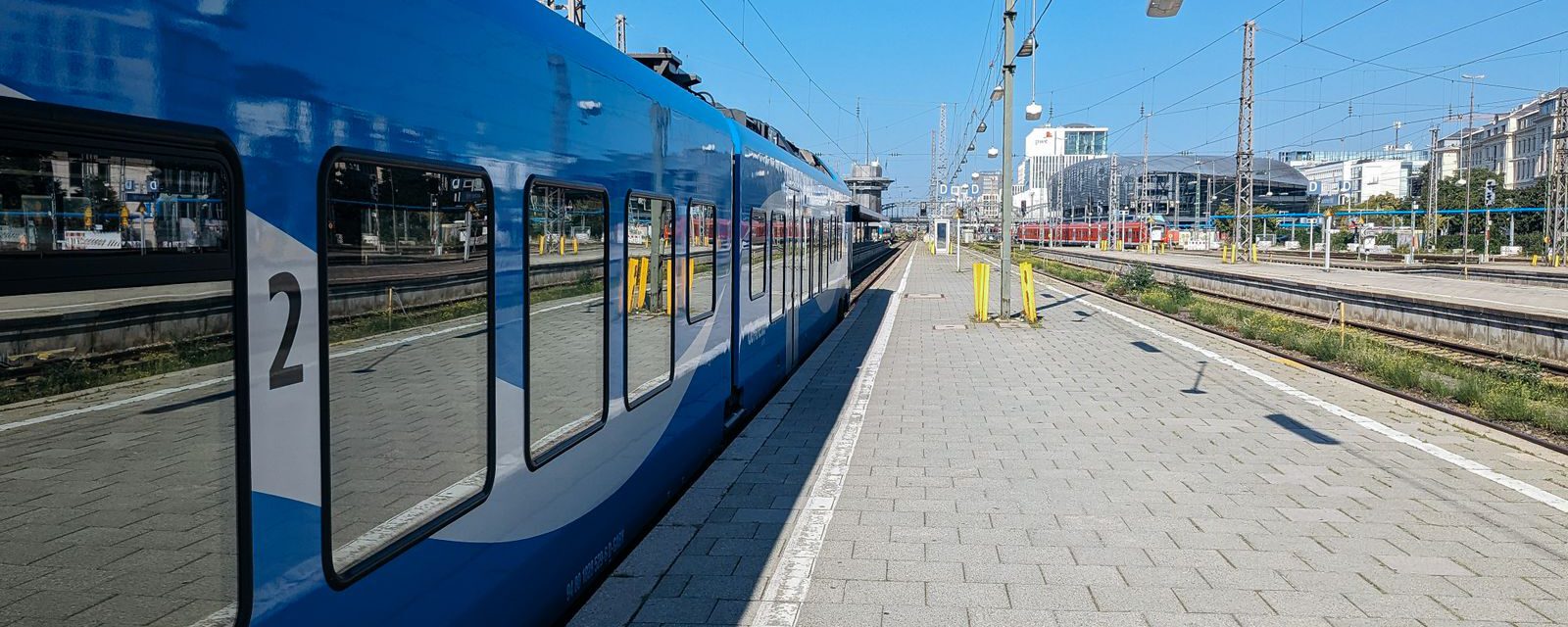 Offener Bahnsteig mit einfahrendem Zug