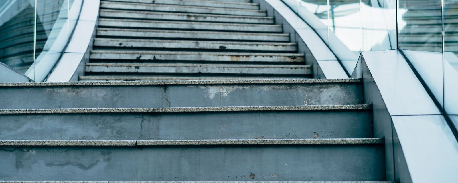 Moderne Betontreppe mit Glasgeländer in einem öffentlichen Gebäude